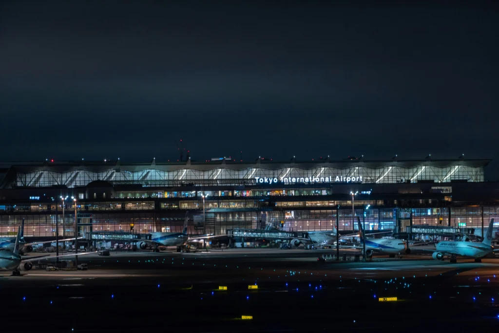 Haneda’s lit international terminal and ramp at night highlight why this airport is best for late arrivals and short stays—minutes to the city via Monorail or Keikyu.