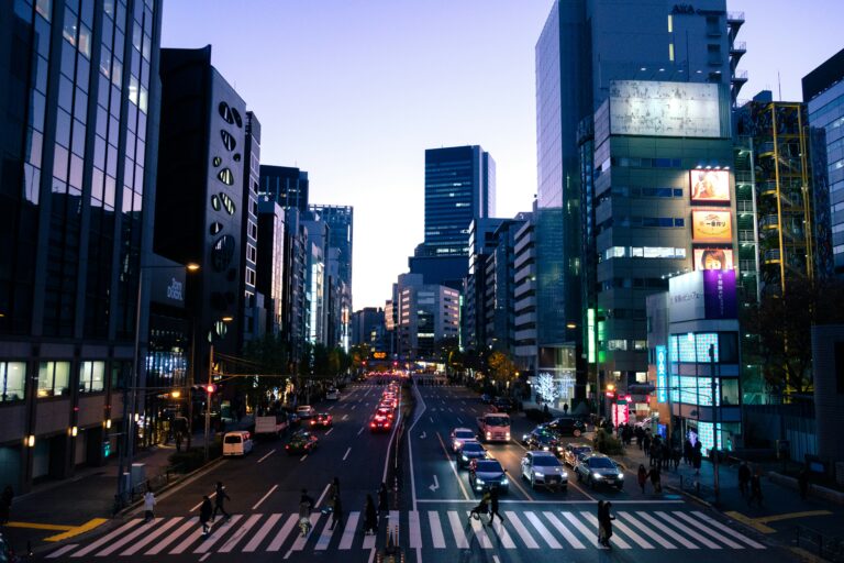 Evening view of a busy Tokyo street with buildings and cars at dusk