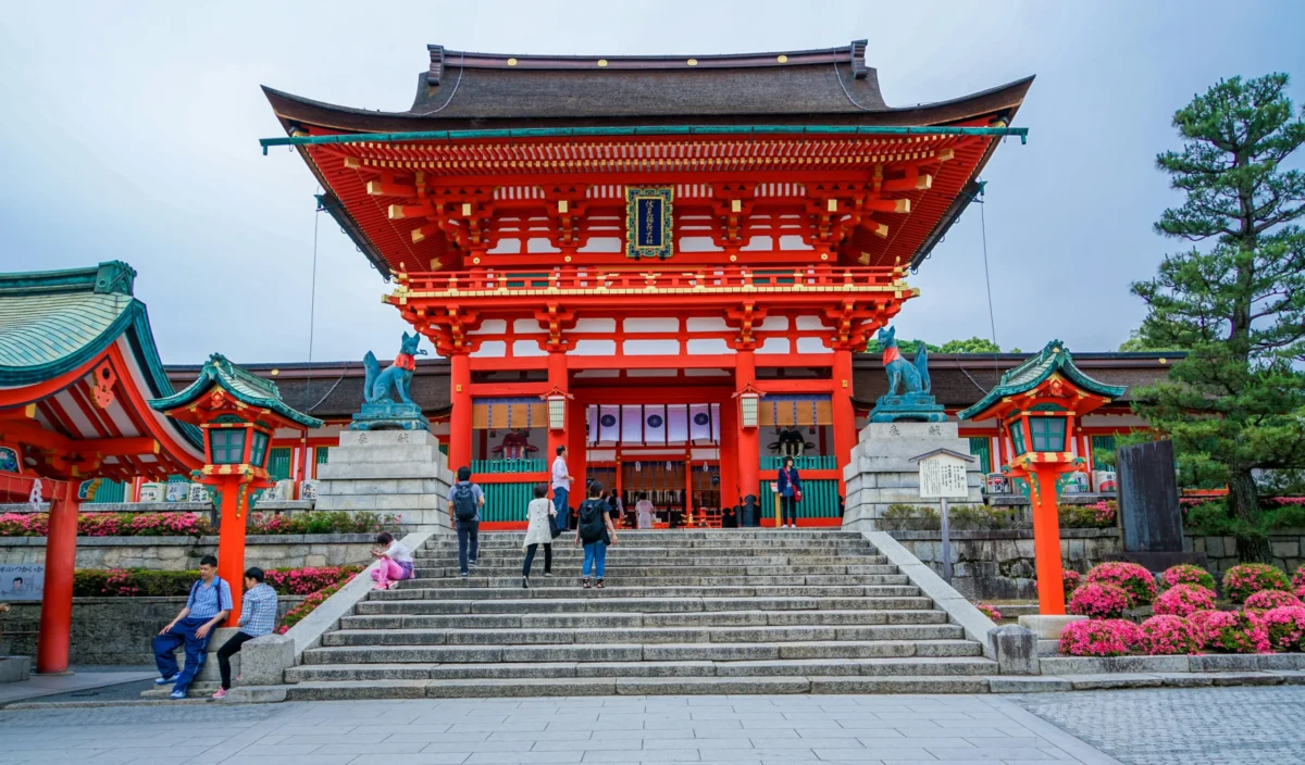 The vibrant vermillion entrance of Fushimi Inari Taisha, one of Kyoto’s most iconic Shinto shrines known for its heritage, fox guardians, and stunning architecture